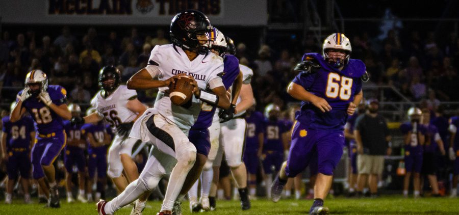 The Circleville quarterback rolls out the pocket, looking downfield for a teammate to pass to, while having McClain defenders on his tail.