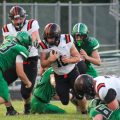 Portsmouth West player is trying to break through a group of Huntington Huntsmen to gain extra yards.