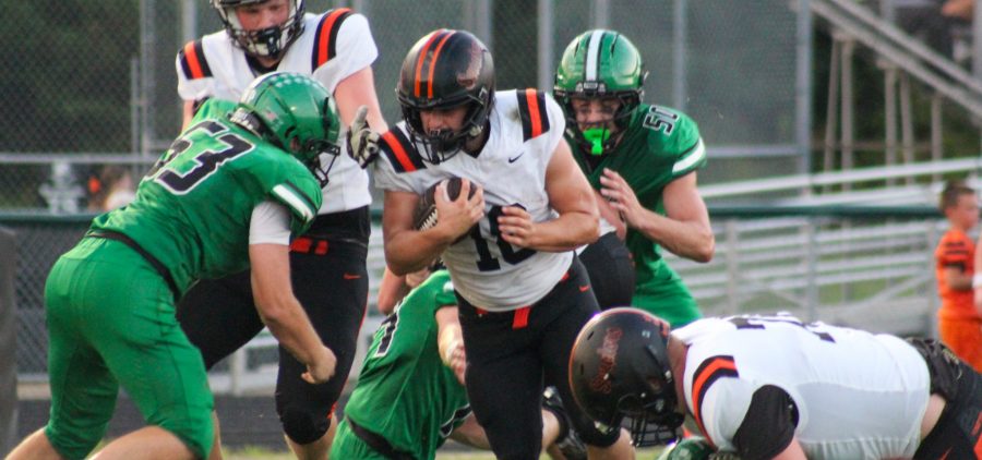Portsmouth West player is trying to break through a group of Huntington Huntsmen to gain extra yards.