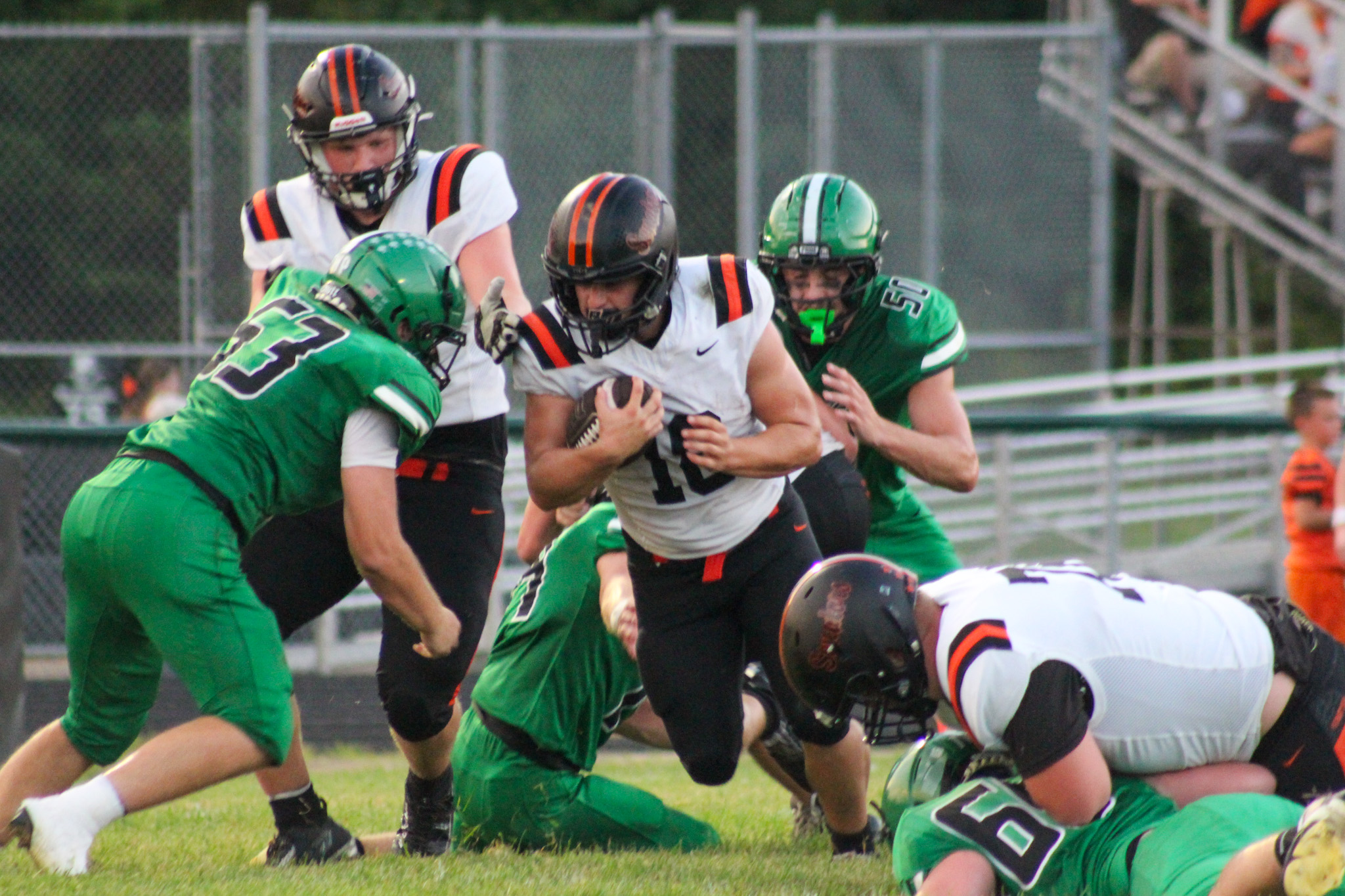 Portsmouth West player is trying to break through a group of Huntington Huntsmen to gain extra yards.