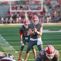 Sheridan is getting to snap the ball to form a play from the quarterback.