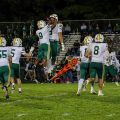 Hamilton Township players are celebrating and jumping in the air after making a big play.