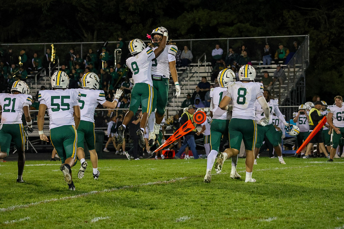 Hamilton Township players are celebrating and jumping in the air after making a big play.