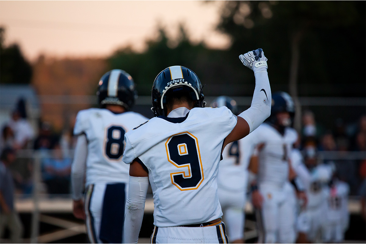 A South Point player is raising his fist in the air with his head down.