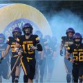 Southern Tornado players are running out of the smoky tunnel.