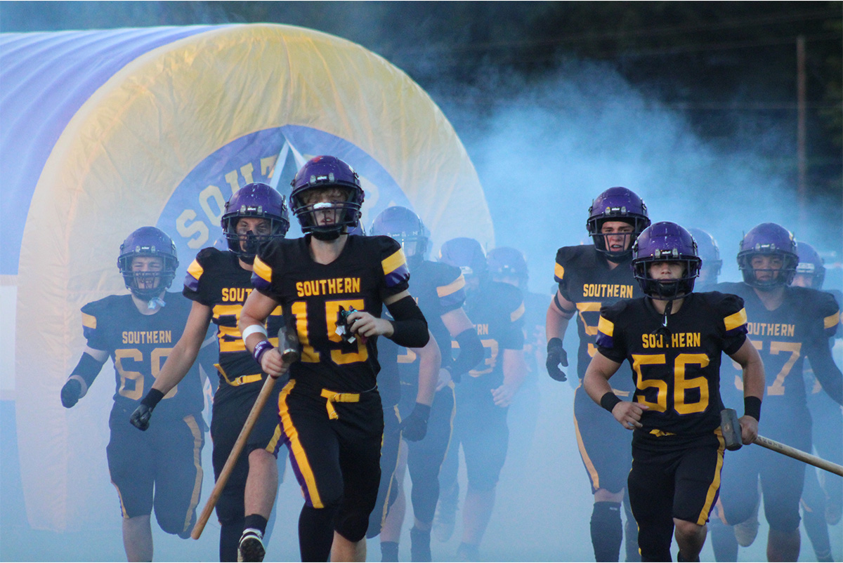 Southern Tornado players are running out of the smoky tunnel.