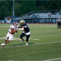 A player from Lancaster is trying to stop an athlete from Pickerington Central who has the ball.