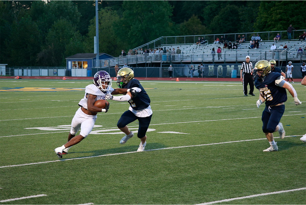 A player from Lancaster is trying to stop an athlete from Pickerington Central who has the ball.