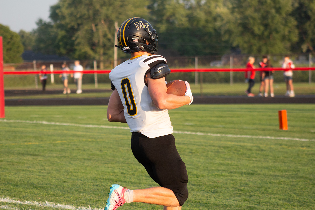 Julian Baker with the football running into the endzone to score a touchdown.