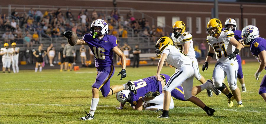 McClain player is running past Paint Valley players to try and reach the end zone.