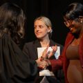 Faith Isaya (right) shakes hands with Judge Suzana Krstevski Koch (left) during her naturalization ceremony in the Brecksville-Broadview Heights High School auditorium.