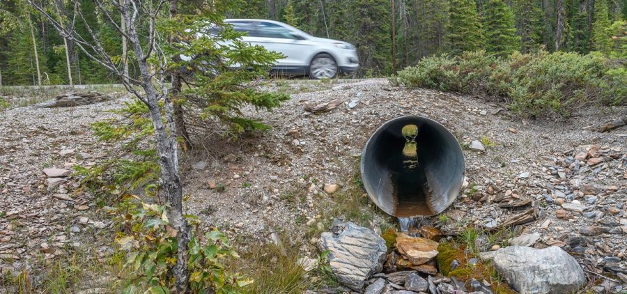 A car drives over a roadway culvert in Yoho National Park, British Columbia, Canada
