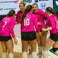 Ohio Volleyball team celebrating after scoring a point against Akron