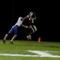player in black jersey up in the air catching a ball off of a player