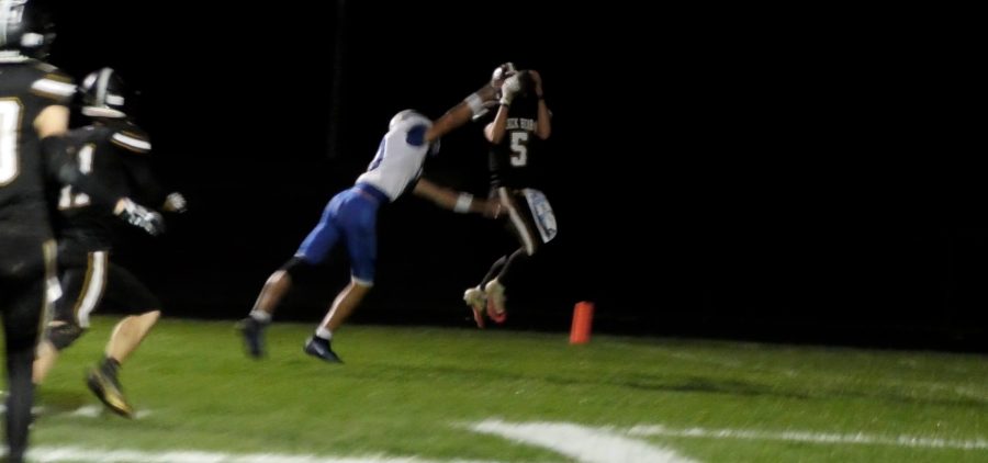 player in black jersey up in the air catching a ball off of a player
