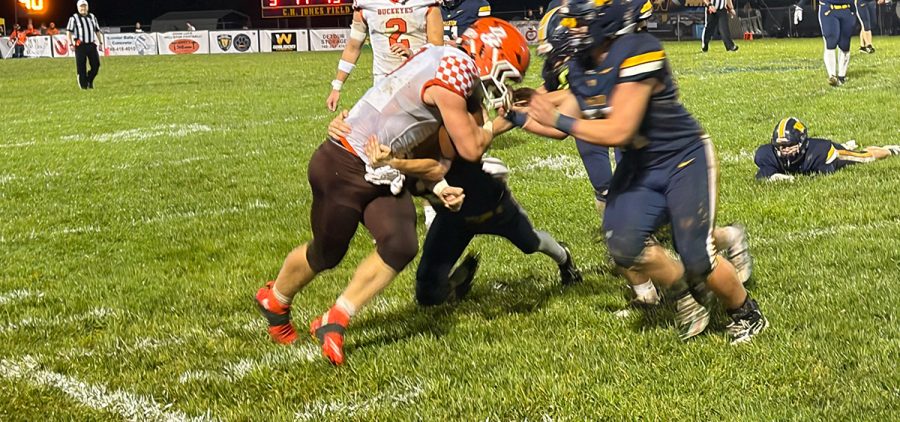 Wellston players are trying to take down Nelsonville-York athlete as he runs the ball.