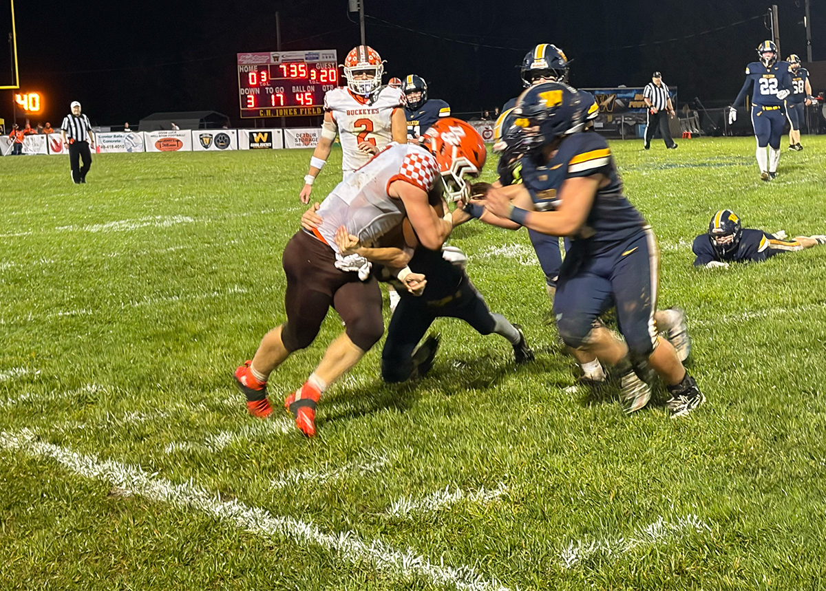 Wellston players are trying to take down Nelsonville-York athlete as he runs the ball.