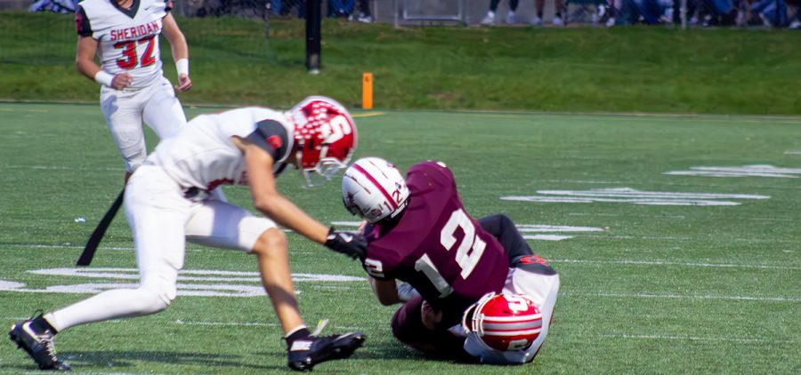 A John Glenn player is being taken down by a Sheridan athlete.