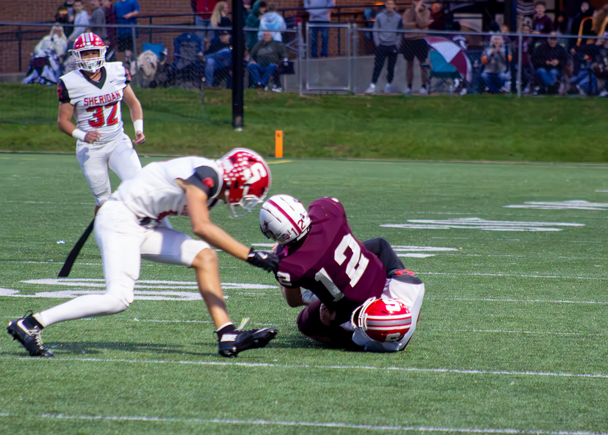 A John Glenn player is being taken down by a Sheridan athlete.