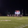 players in black and white jerseys line up on the field.