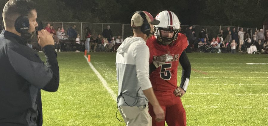 The Bishop Rosecrans' quarterback and coach meet to discuss the next play call.