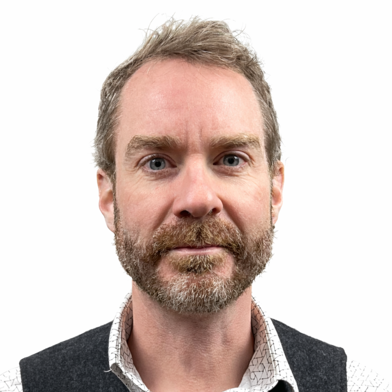 A portrait of John Staser in front of a white background.