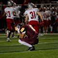 Meigs player kneeling on the field in a maroon jersey
