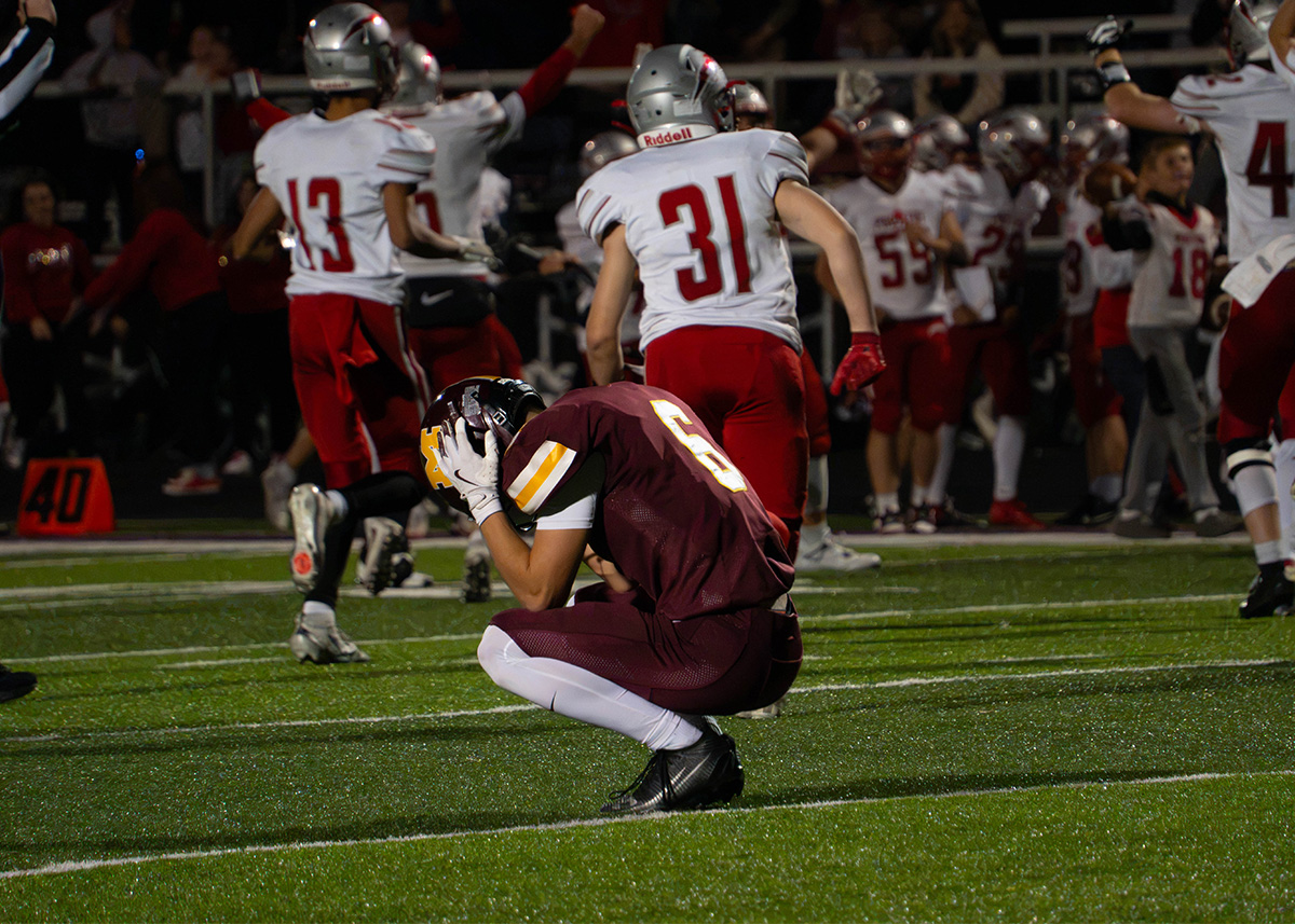 Meigs player kneeling on the field in a maroon jersey