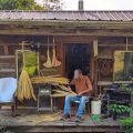 Curt Cable makes a broom on the porch of his workshop in Morgan County.