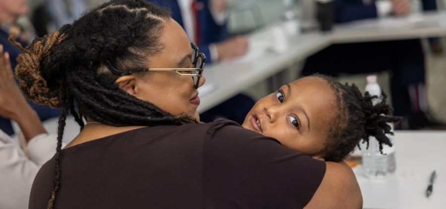 Shemya Wilson holds her son while sitting at a table.