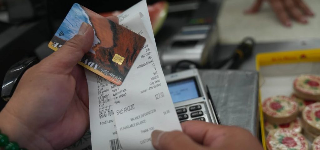 A SNAP recipient checks her balance left after purchasing food supplies with a California EBT card