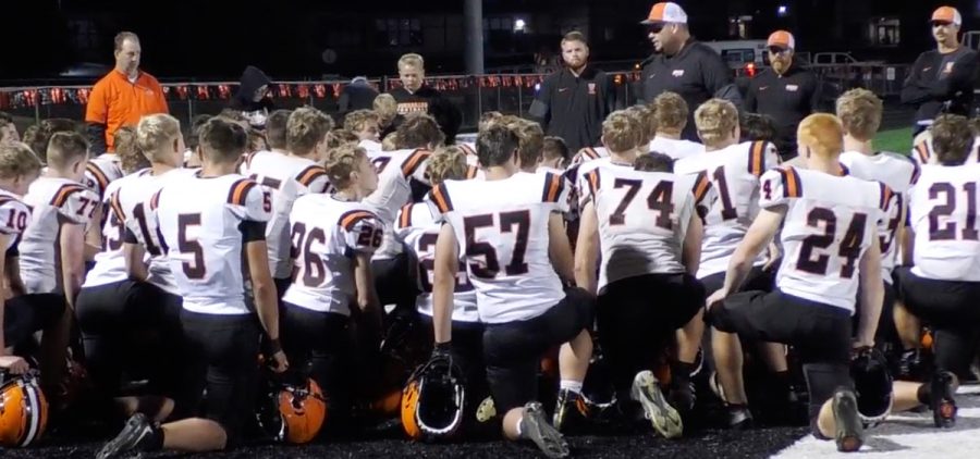 Versailles players huddled with their coach in white jerseys
