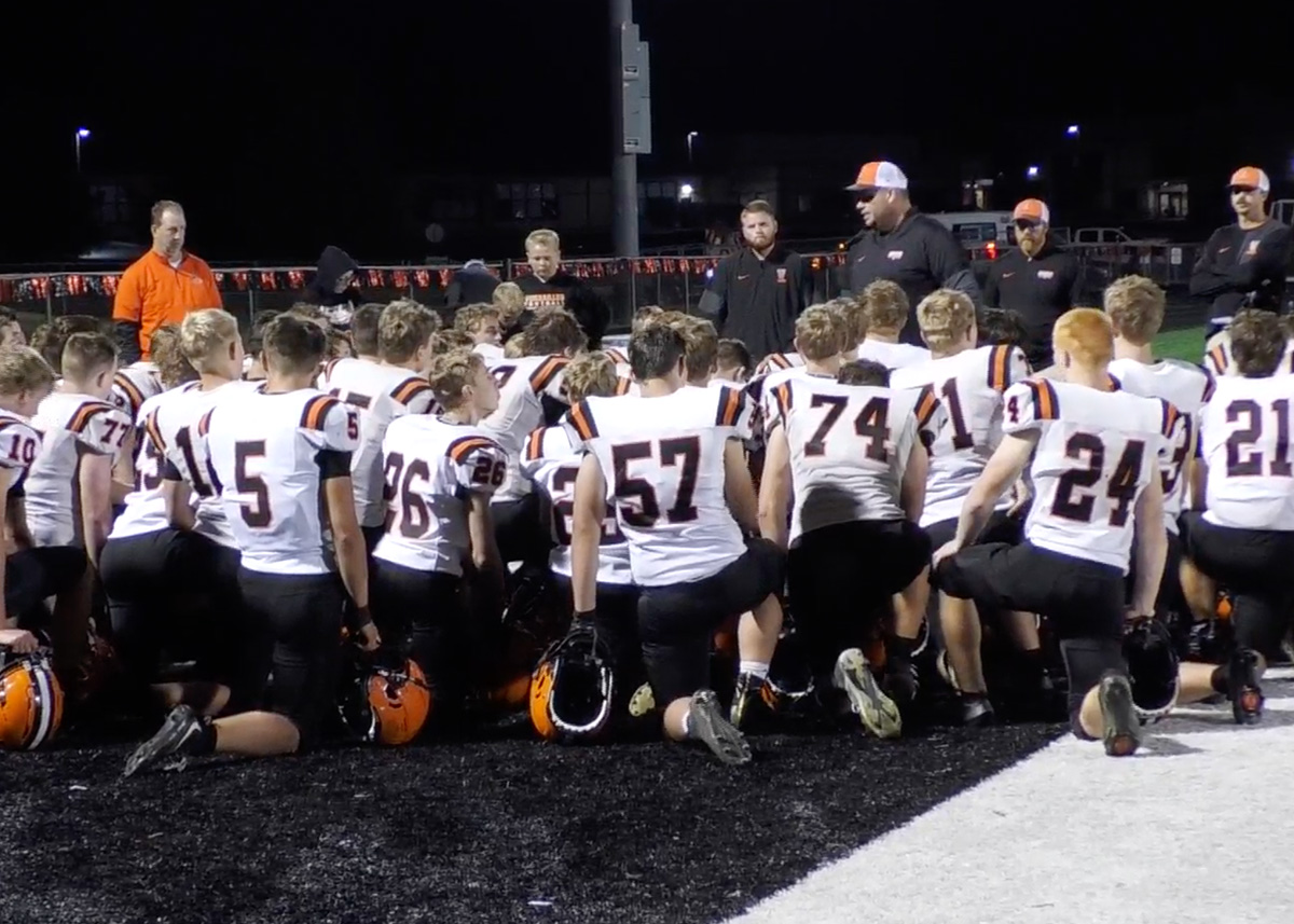 Versailles players huddled with their coach in white jerseys
